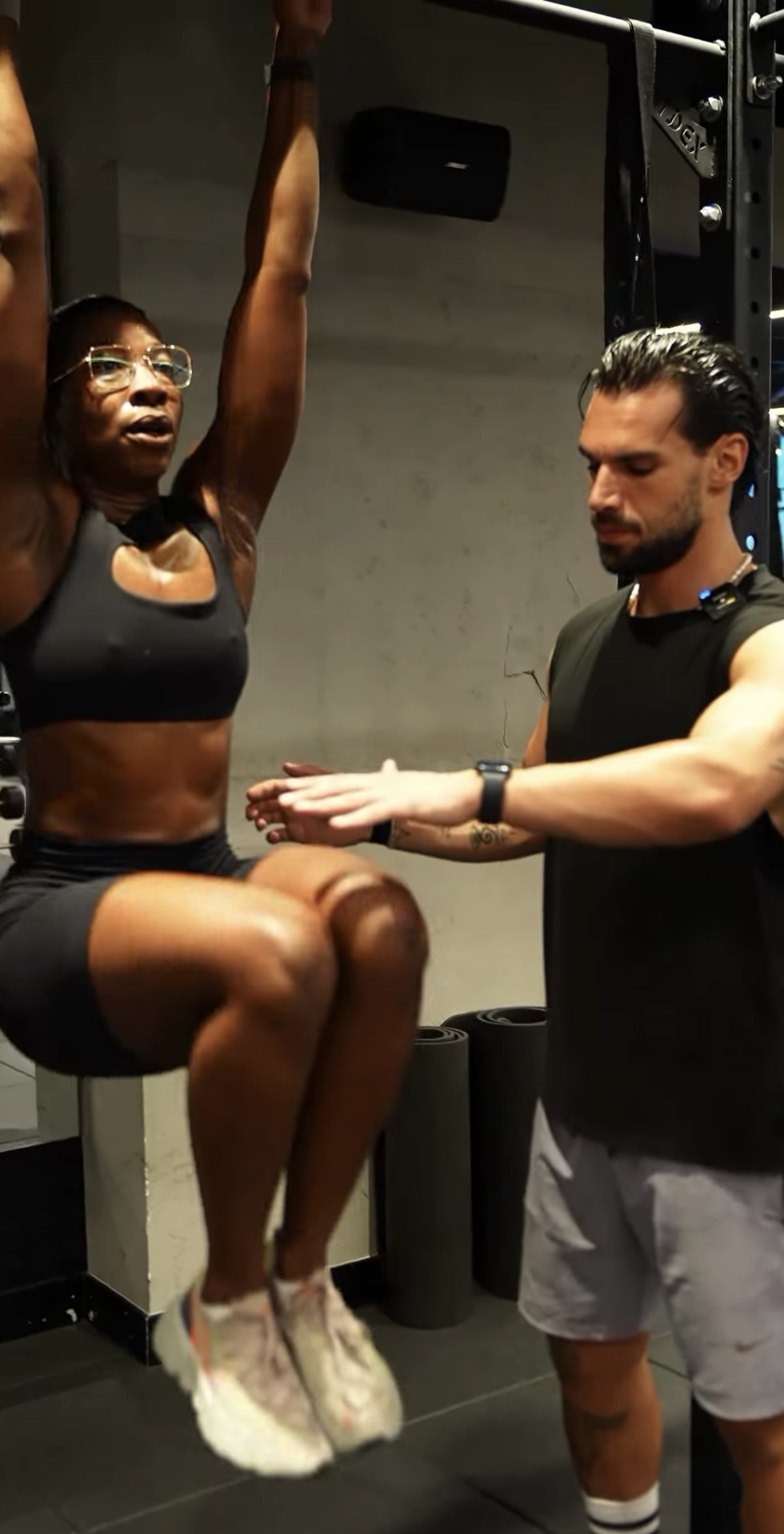 Coach guiding a client through a bodyweight exercise in the studio