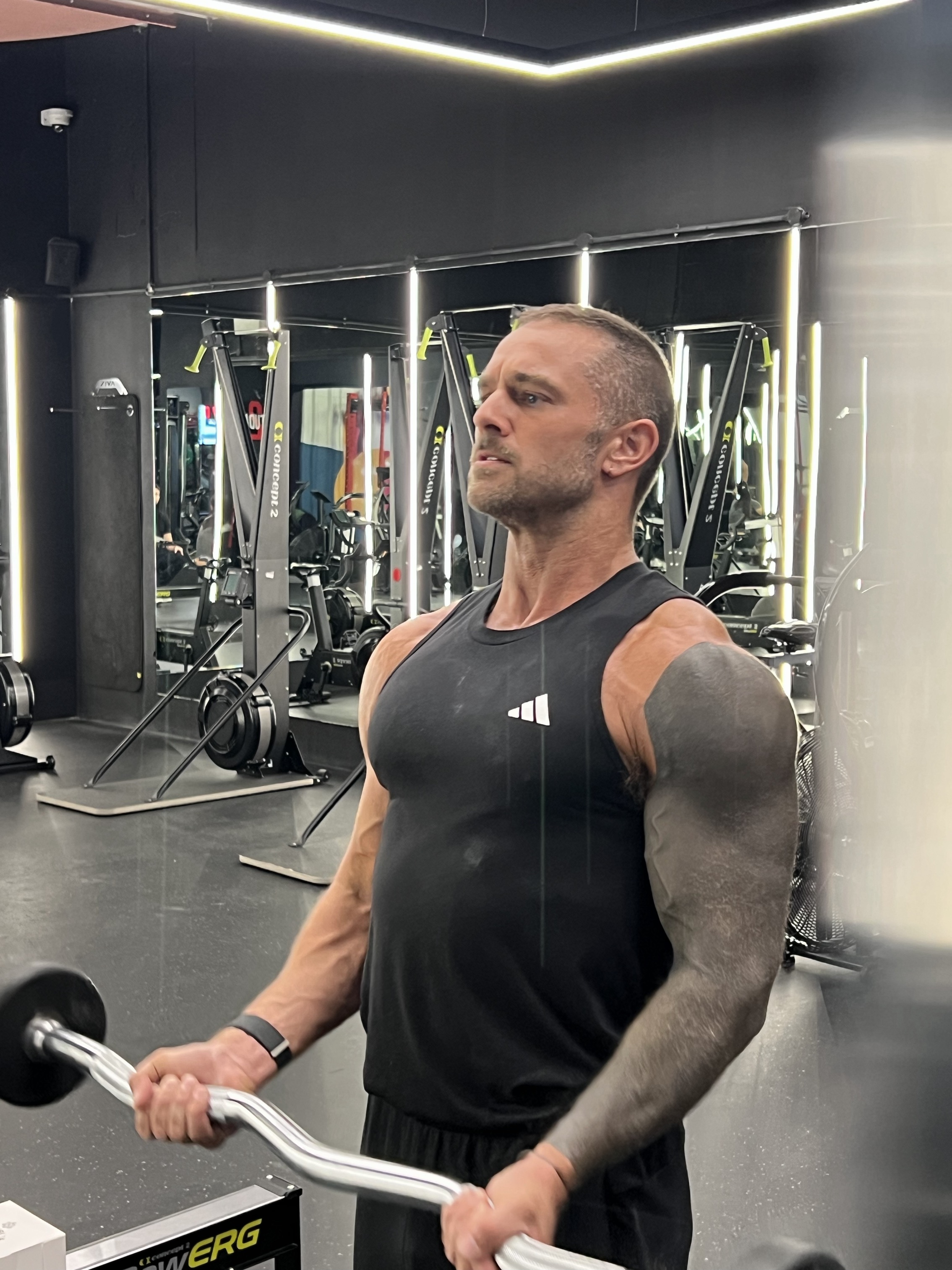 Client focused on a barbell curl in a Dubai performance gym