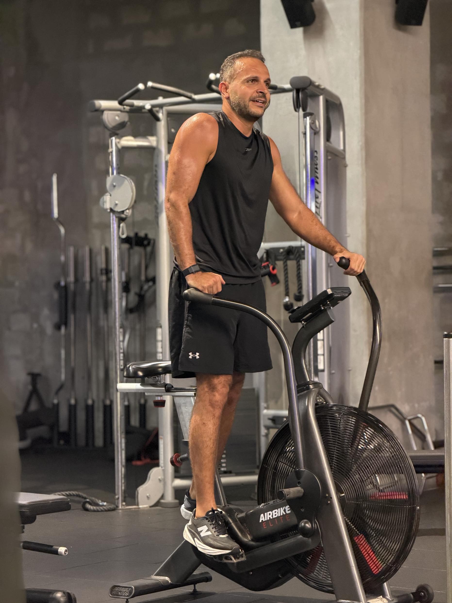 Client pushing through an air-bike session in a Dubai gym