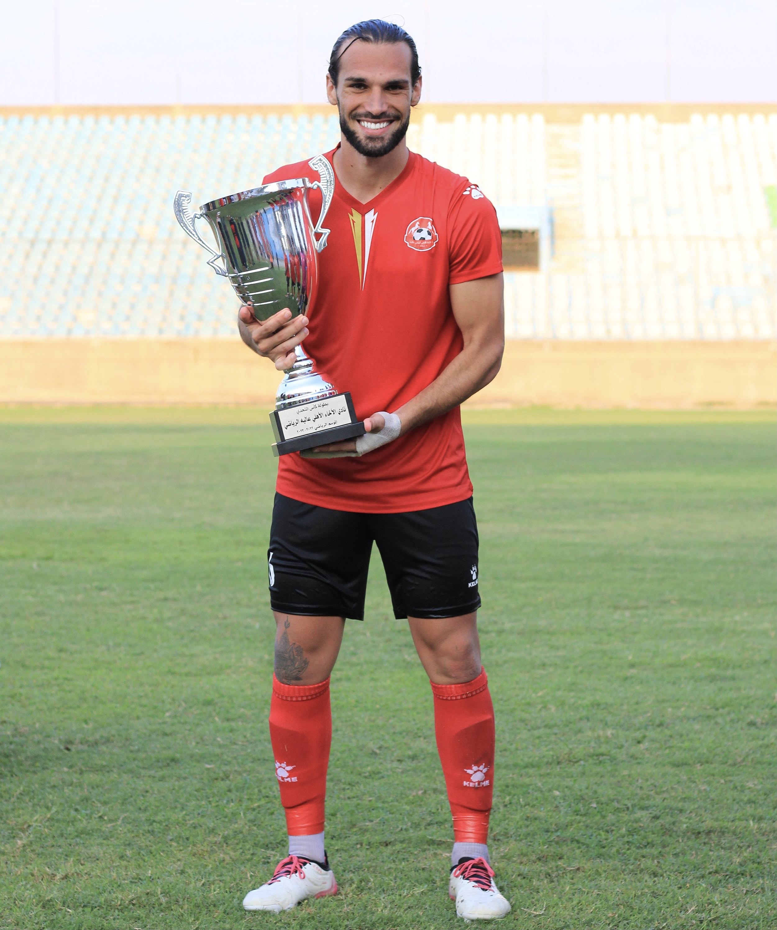 Carlos Lomba holding a championship trophy in his playing kit